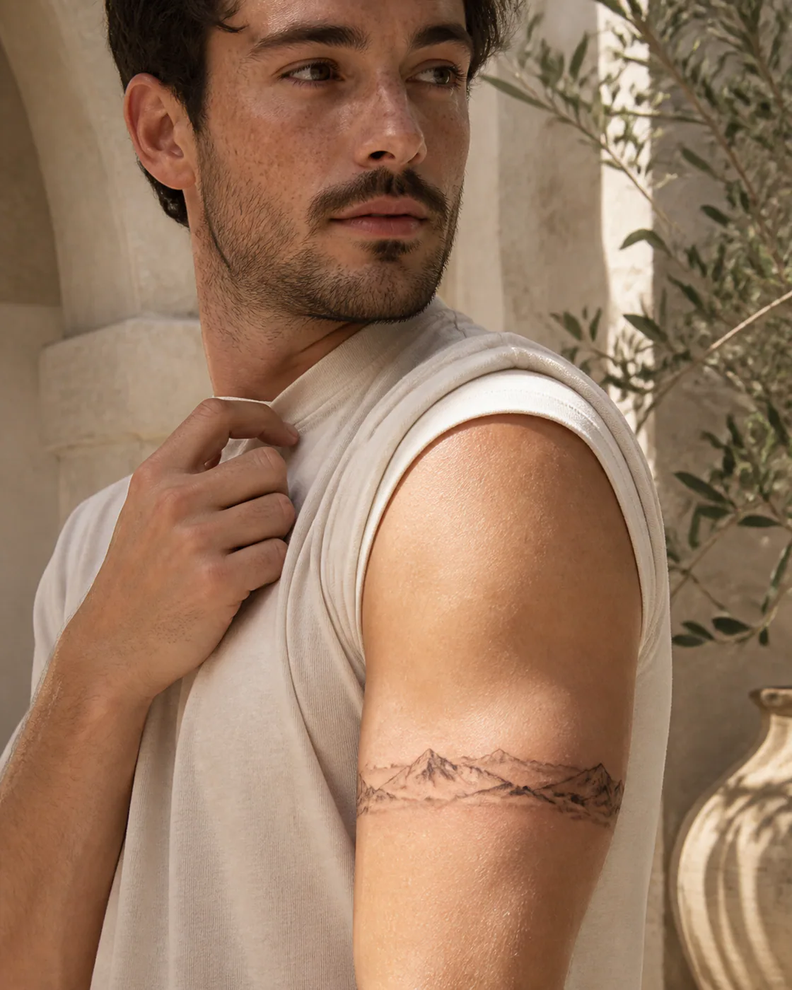 Fine Line tattoo of an alpine ridge layered with wind-driven mist on the armband