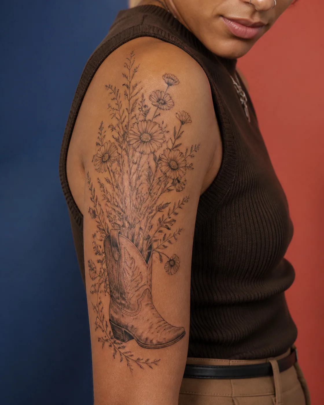 Fine Line tattoo of a worn cowboy boot overflowing with wildflowers on the half sleeve