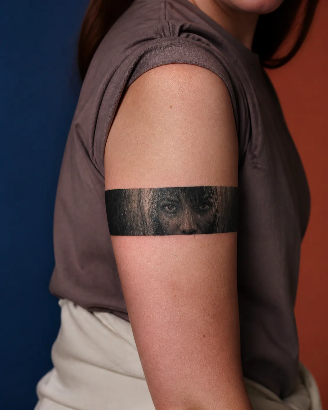 Minimalist tattoo of an anonymous man looking through a veil of rain executed as a healed cover-up on the armband