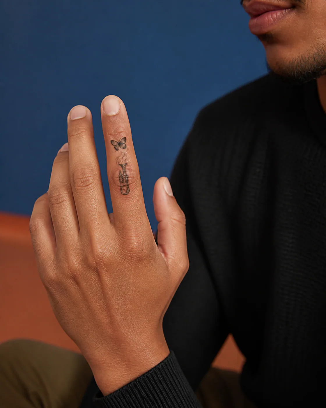 Japanese tattoo of a brass trumpet releasing a curl of abstract smoke with an integrated butterfly on the finger