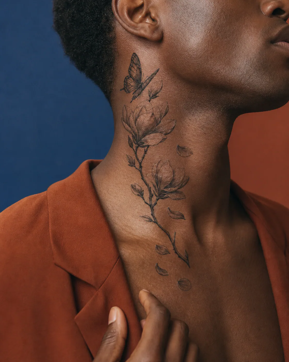 Surrealism tattoo of a flowering magnolia branch with falling petals with an integrated butterfly on the side of neck
