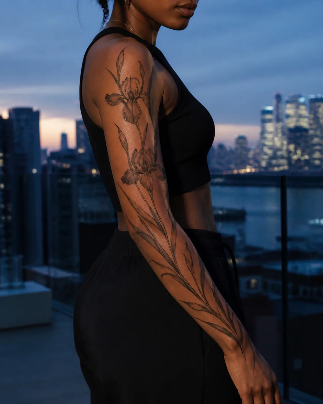 Minimalist tattoo of a tall iris arrangement with blade-like leaves on the full sleeve