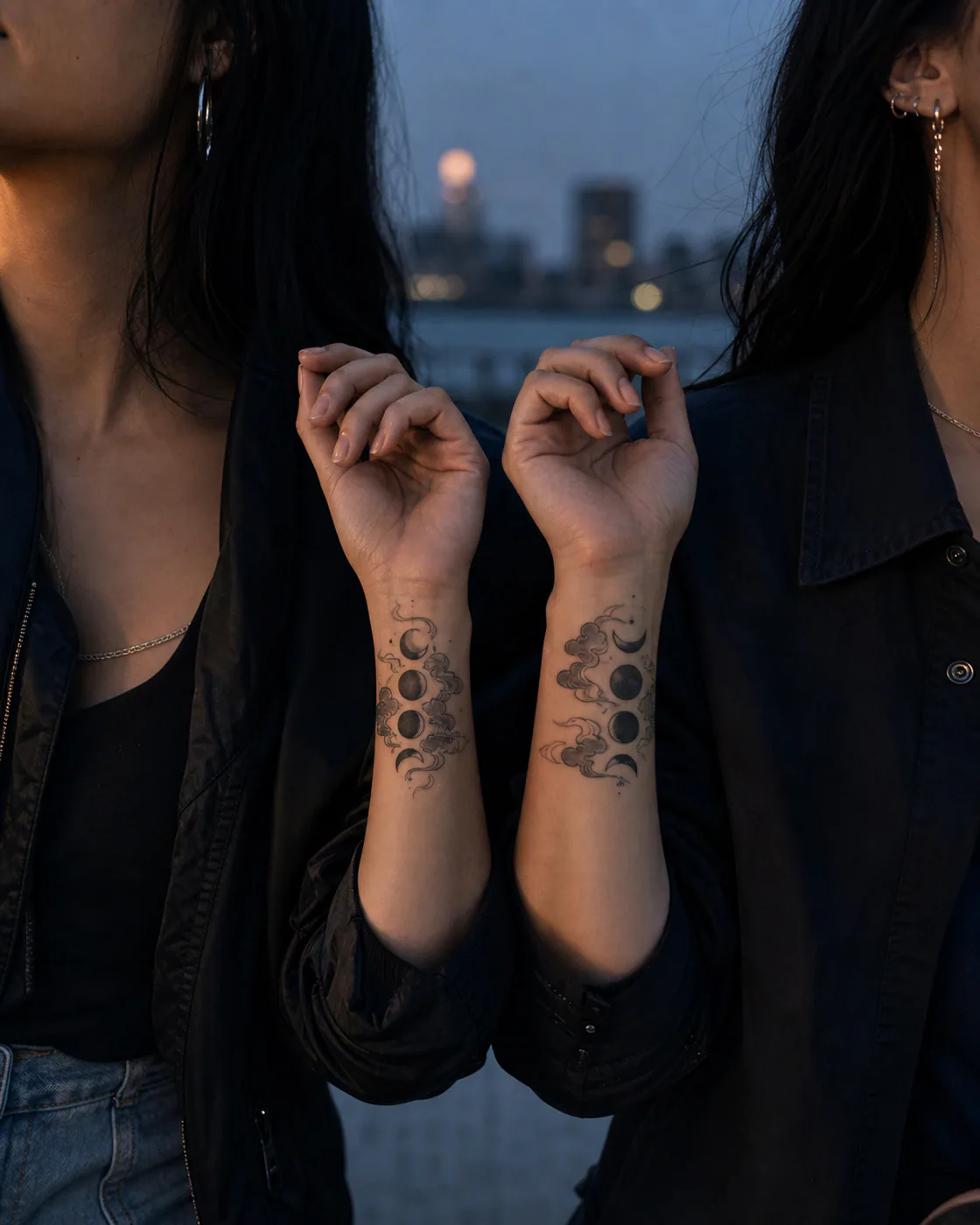 Japanese tattoo of moon phases drifting between translucent clouds as a complementary couple tattoo pair on the wrist
