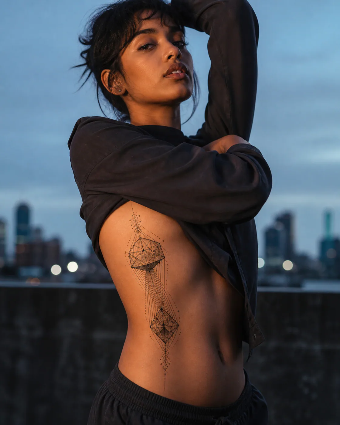 Ornamental tattoo of a split polyhedron held together by fine parallel lines on the side ribs