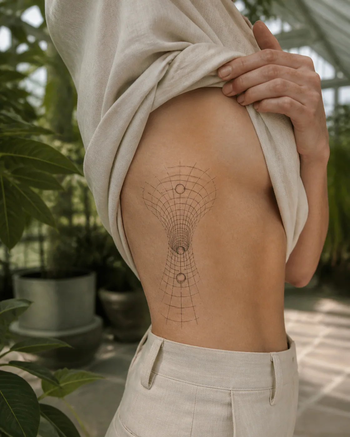 Minimalist tattoo of a wave grid folding into an optical tunnel with a three-part family motif on the side ribs