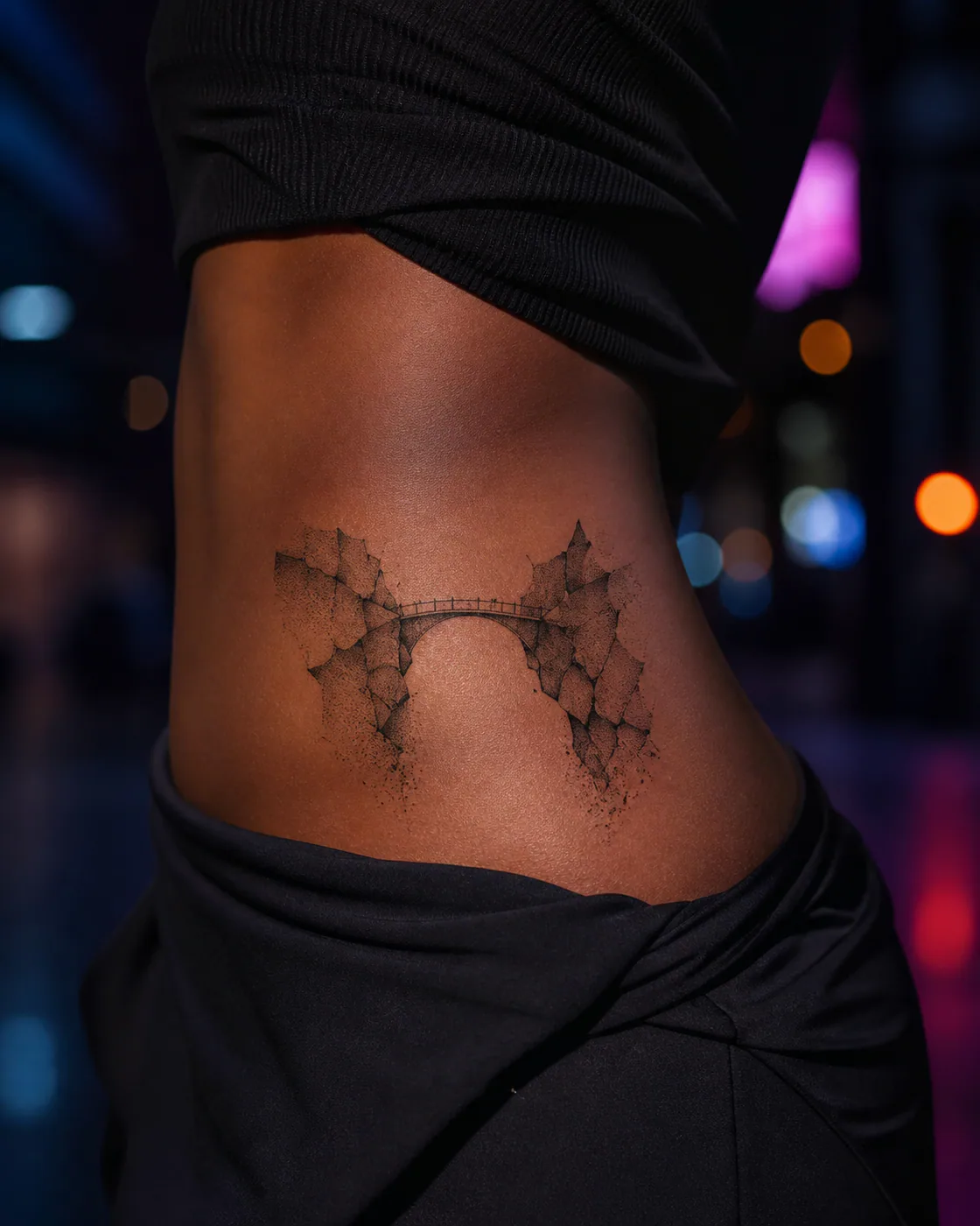 Dotwork tattoo of a narrow bridge joining two fractured stone forms on the hip