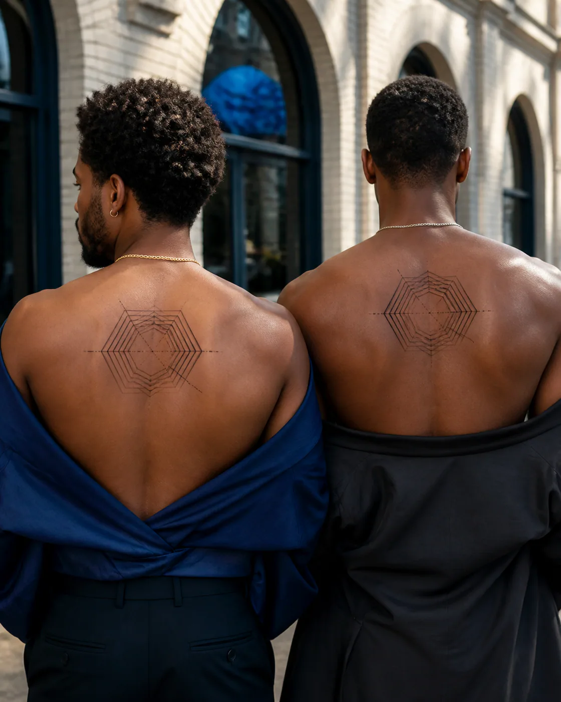 Geometric tattoo of offset hexagonal rings collapsing into one diagonal seam as a complementary couple tattoo pair on the upper back