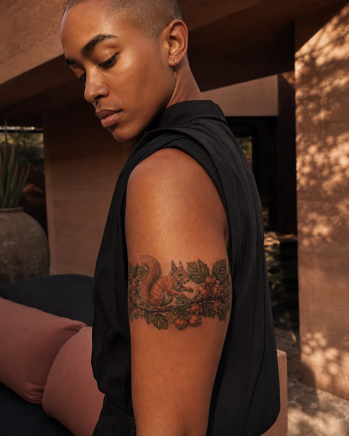 Neo-Traditional tattoo of a red squirrel balancing on a hazelnut branch executed as a healed cover-up on the armband