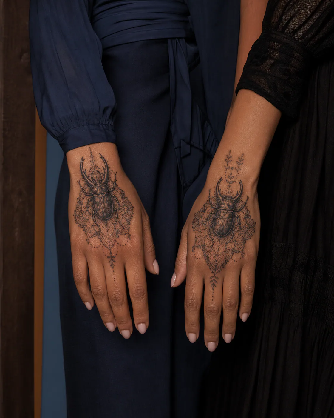 Dotwork tattoo of a horned beetle resting on an embroidered mourning veil as a complementary couple tattoo pair on the back of hand