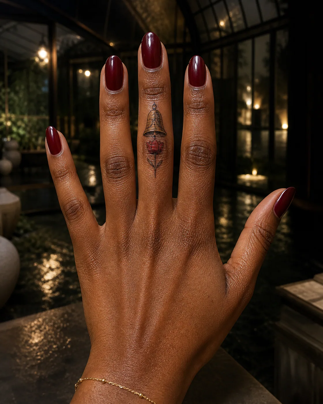 Neo-Traditional tattoo of a cracked bell sheltering a newly opened flower on the finger