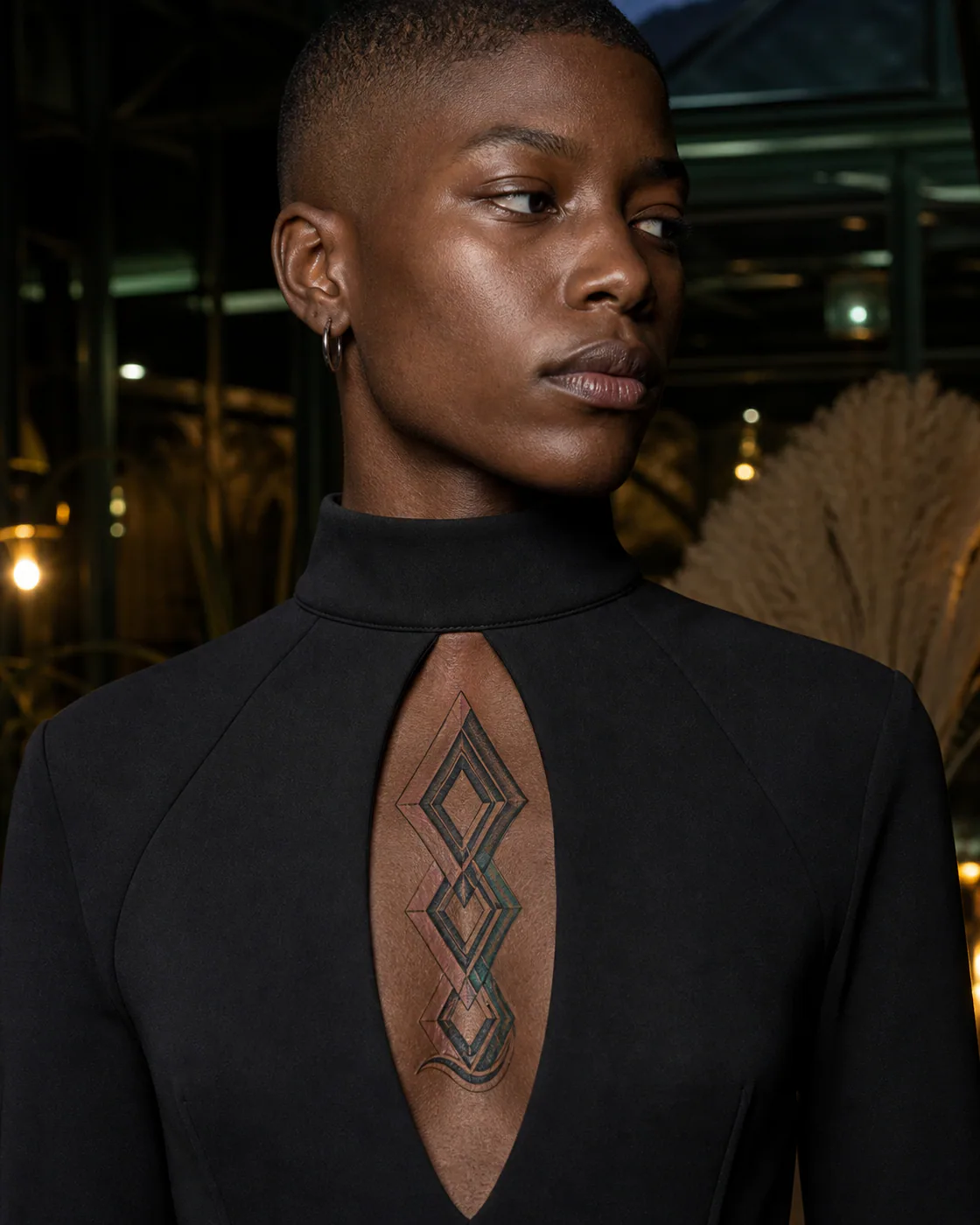 New School tattoo of nested diamonds rotating into a soft wave boundary on the sternum