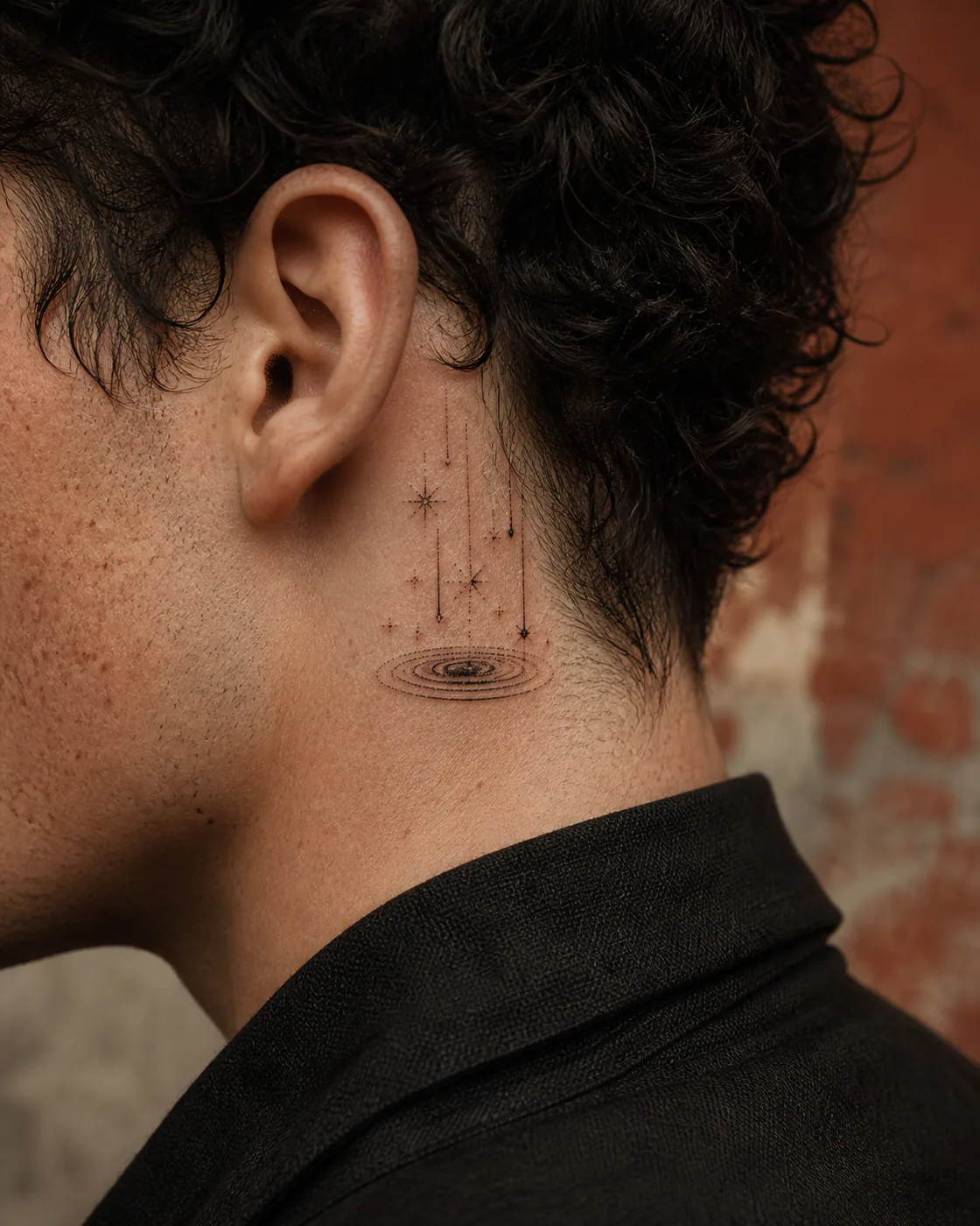 Dotwork tattoo of a field of falling stars reflected in a circular pool on the behind the ear