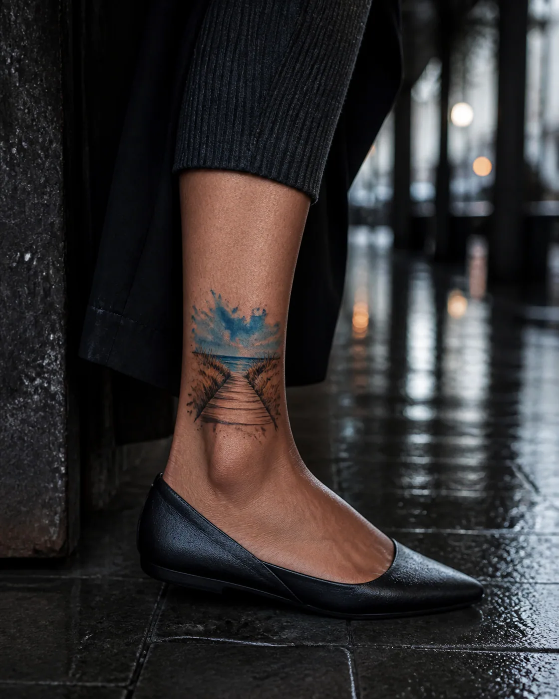Watercolor tattoo of a coastal footbridge crossing wind-shaped dunes on the ankle