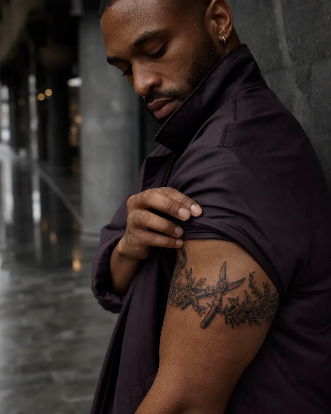 Floral tattoo of a pair of garden shears beside freshly cut rosemary on the armband