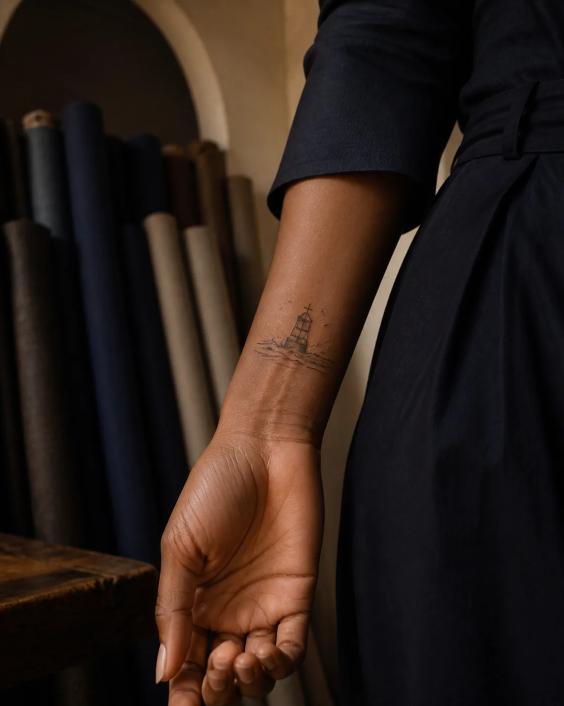 Minimalist tattoo of a weather buoy leaning through a rising winter swell on the wrist