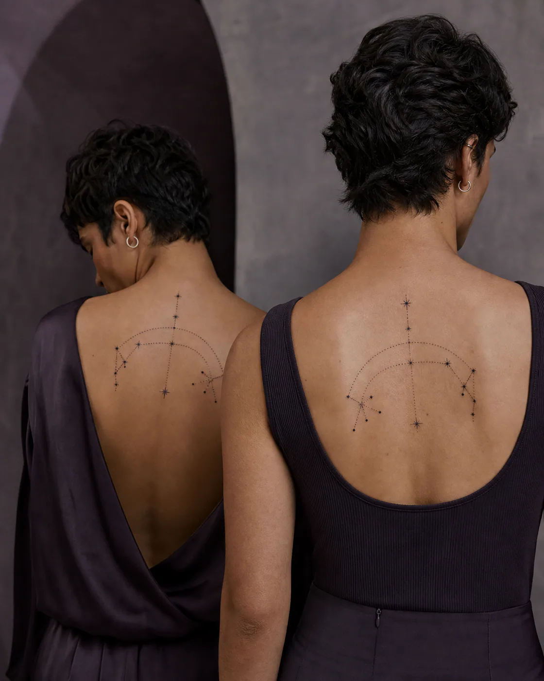 Geometric tattoo of two small charm constellations connected by matching dotted arcs as a complementary couple tattoo pair on the upper back