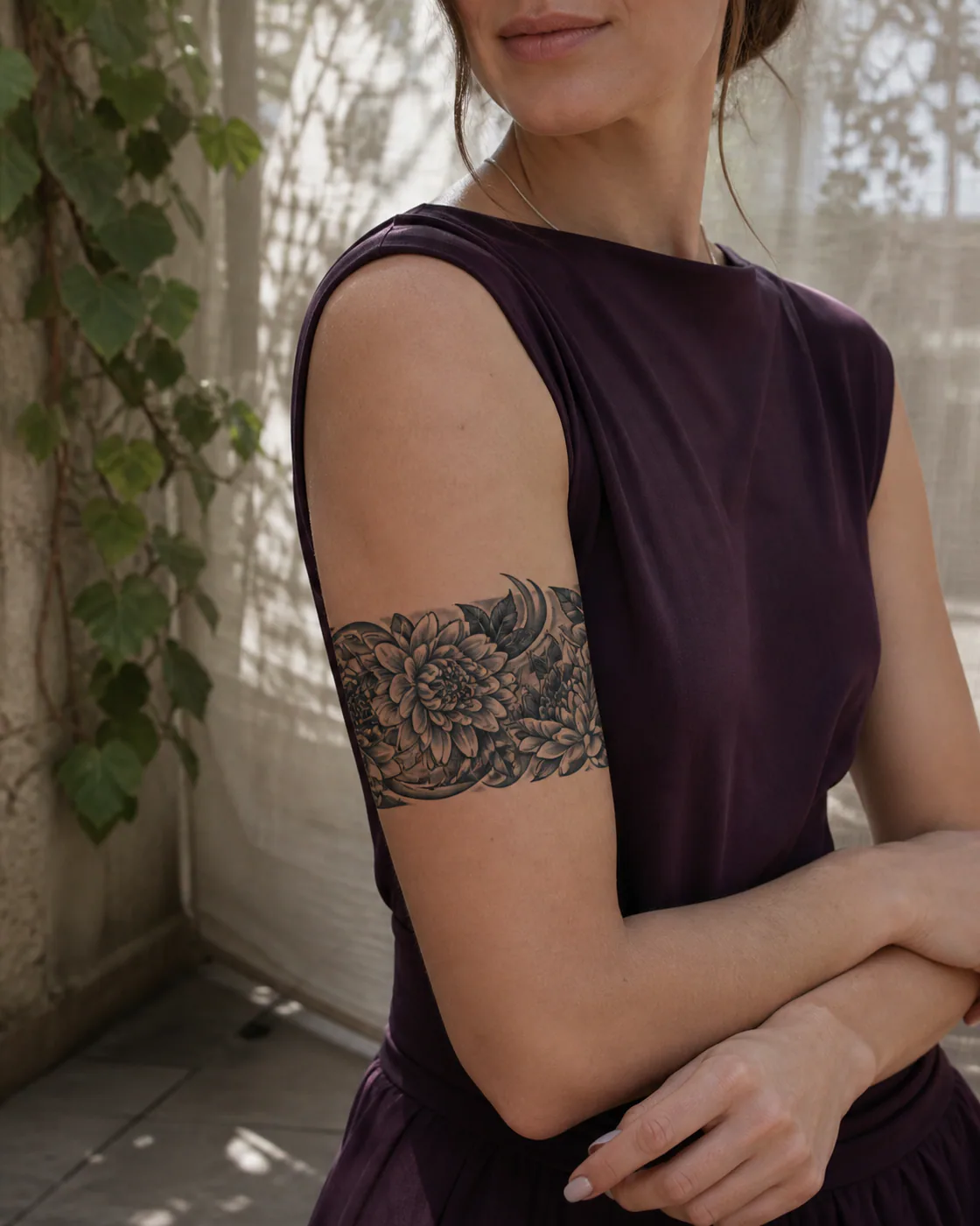 Tribal tattoo of layered chrysanthemums and dark leaves replacing an old flower cluster executed as a healed cover-up on the armband