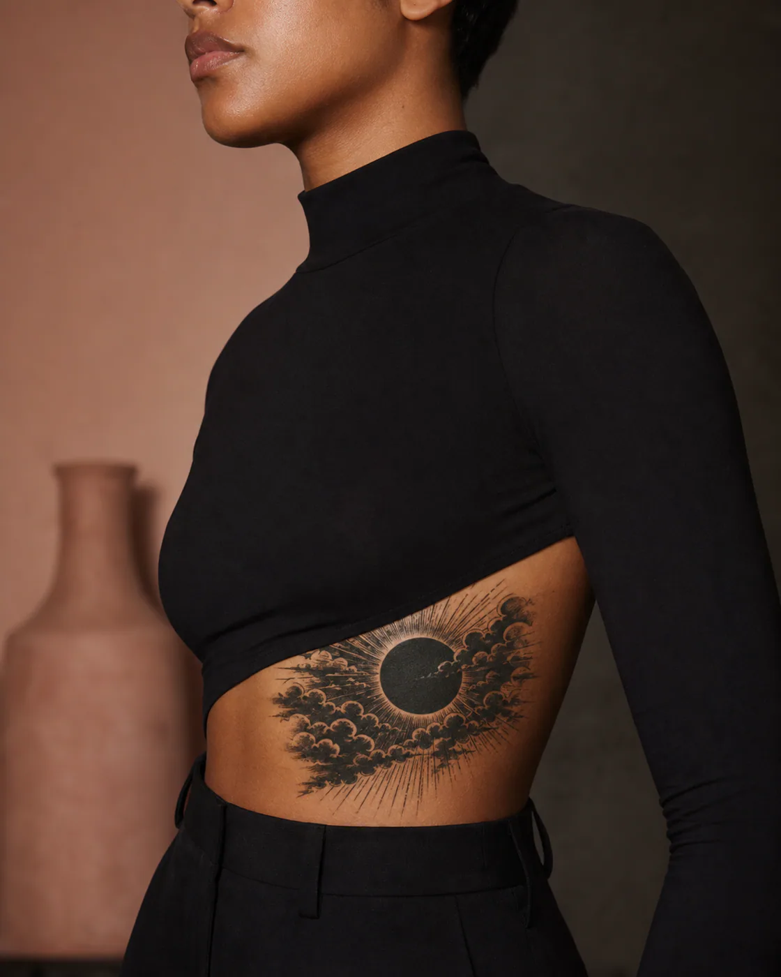 Blackwork tattoo of a deep eclipse field and radiating clouds covering a blurred circular mark executed as a healed cover-up on the side ribs