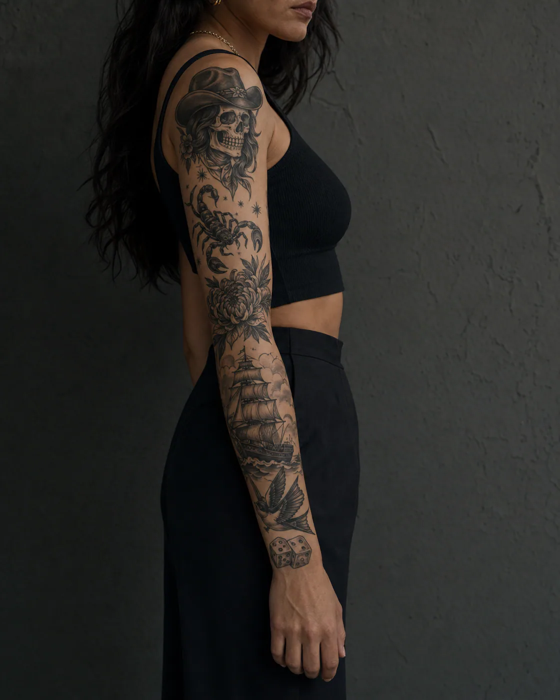 American traditional patchwork sleeve tattoo featuring a cowgirl skull, scorpion, ship, raven, dice, and chrysanthemum on olive skin