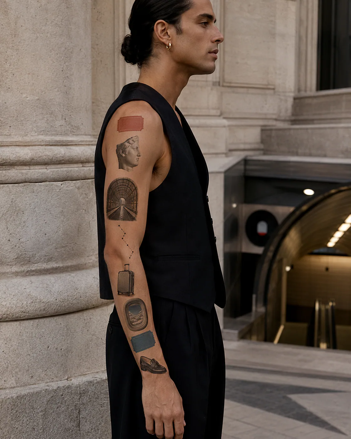Micro-realism patchwork sleeve tattoo with an abstract travel ticket, marble profile sculpture, airplane window, espresso cup, and olive branch on olive skin